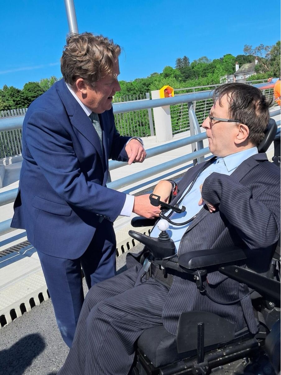 Derek Spaight speaking with a public representative during an accessibility-related visit.